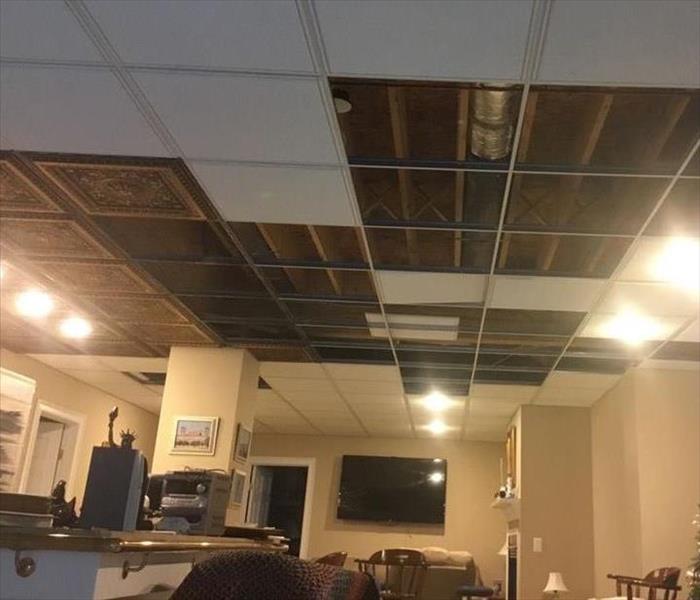A ceiling in a home with random tiles removed 