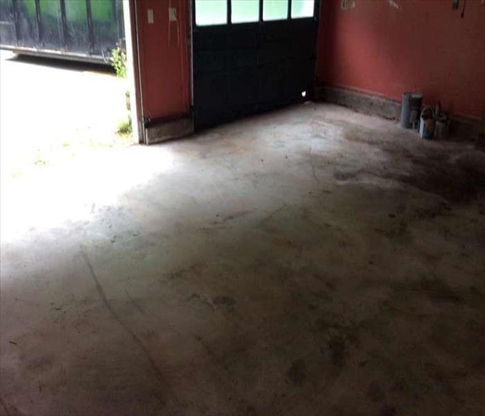 A cleared-out basement with exposed concrete floor ready for deep cleaning