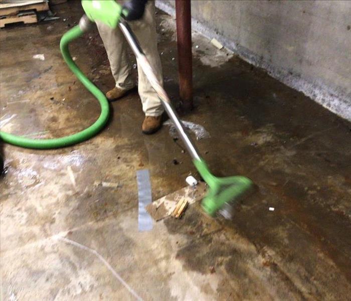 Basement with SERVPRO extraction equipment with water on the floor