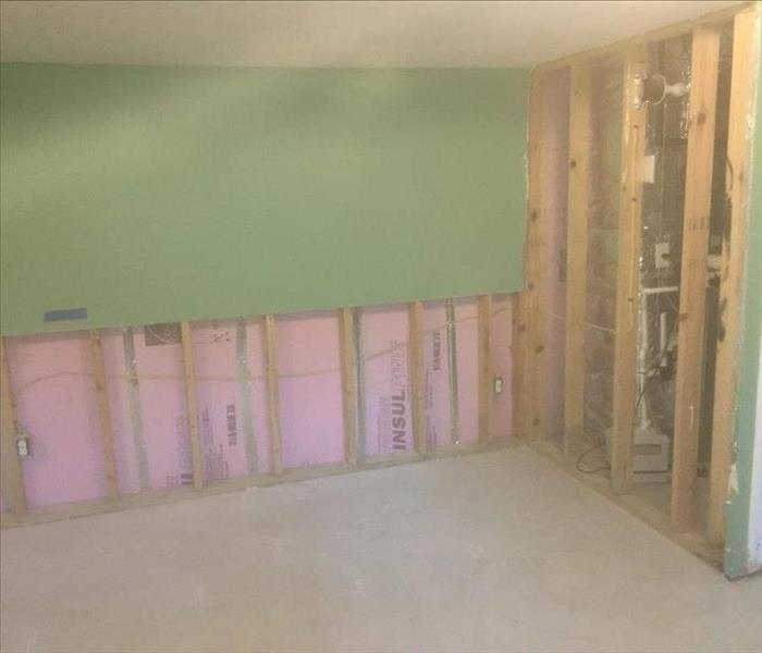 Basement with drywall cut and removed exposing studs to about 2 feet above the floor